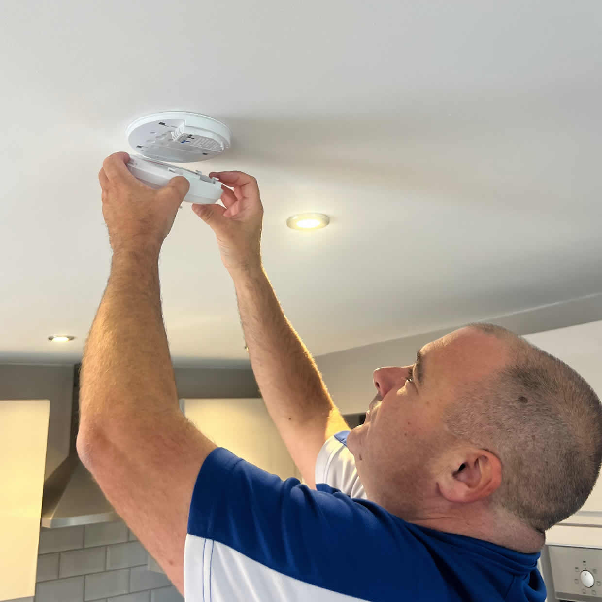 Smoke alarm being installed on a ceiling in Newtownabbey